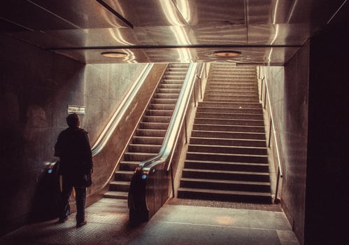 man on train station escalator photo