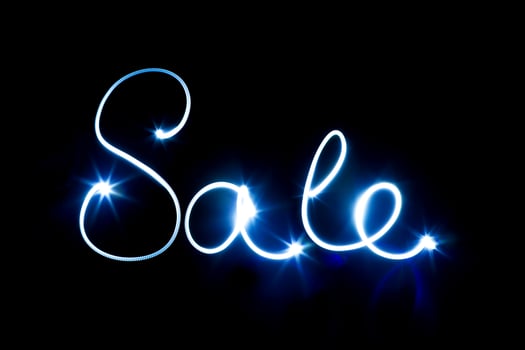 Glowing inscription SALE on a black photo