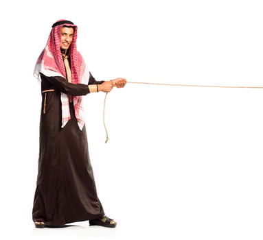 Young Arab pulling a rope isolated on white photo