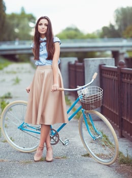 Young beautiful, elegantly dressed woman with bicycle photo