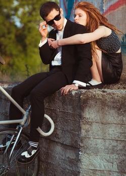 Young stylish guy with girl and the bicycle outdoors photo