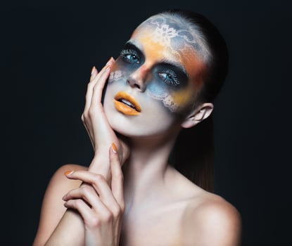 Portrait of beautiful glamor girl with dark eye make-up in the form of lace and orange lips photo