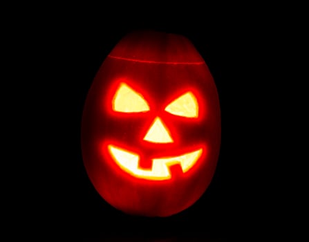 Halloween pumpkin jack-o-lantern candle lit, isolated on black photo