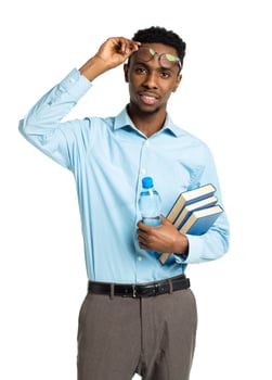 Happy african american college student standing with books and bottle of water in his hands on white photo