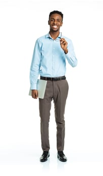Happy african american college student standing with laptop on white photo