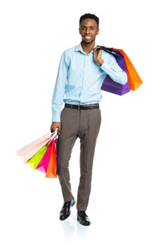 Happy african american man holding shopping bags on white background photo