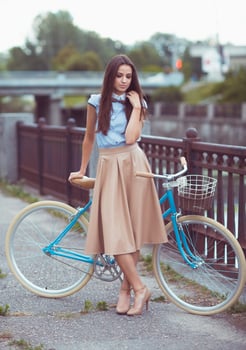 Young beautiful, elegantly dressed woman with bicycle photo
