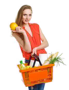 Happy woman holding a basket full of healthy food. Shopping photo