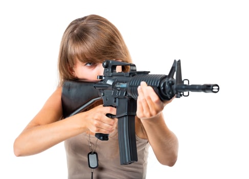 Soldier young beautiful girl dressed in a camouflage with a gun in his hand on white photo