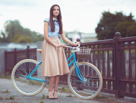 Young beautiful, elegantly dressed woman with bicycle photo