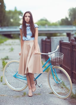 Young beautiful, elegantly dressed woman with bicycle photo