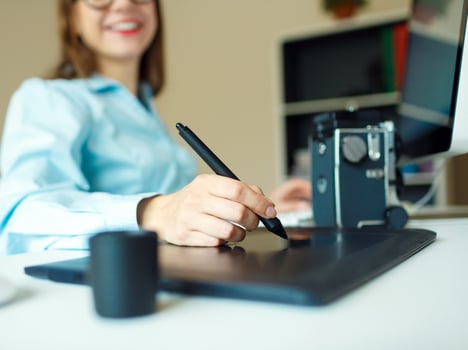Young artist drawing something on graphic tablet at the home office photo
