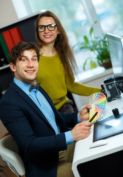 Young colleague looking to a color paint palette at home office photo