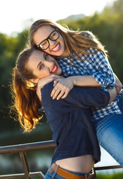 Two playful girls having fun outdoors at sunset light photo