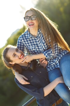 Two playful girls having fun outdoors at sunset light photo