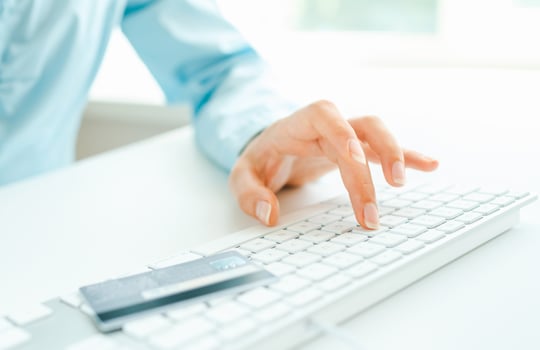 Female hands using computer and credit card on it photo