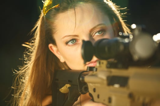 Girl with a gun for trap shooting aiming at a target photo