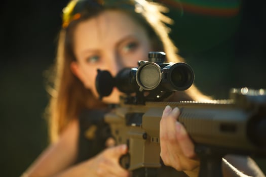 Girl with a gun for trap shooting aiming at a target photo