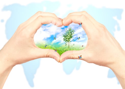 Human hand and nature on world map background. photo