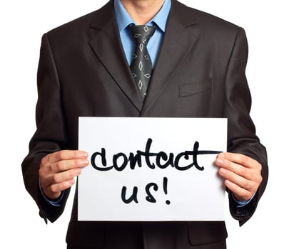 Young businessman points on a card Contact Us on a white photo
