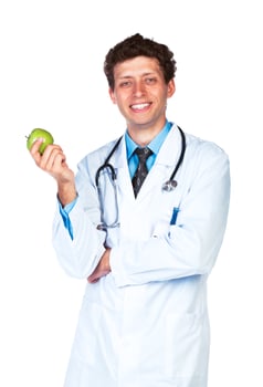 Portrait of a smiling male doctor holding green apple on white photo