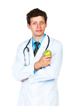 Portrait of a smiling male doctor holding green apple on white photo