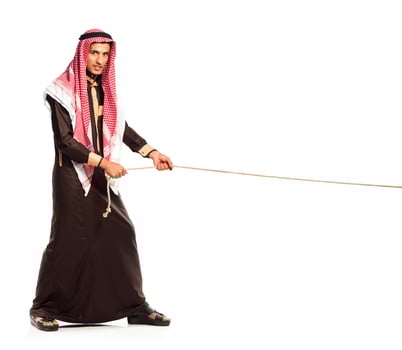 Young Arab pulling a rope isolated on white photo
