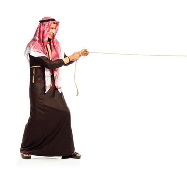 Young Arab pulling a rope isolated on white photo