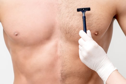 Beautician shaves chest of young man photo