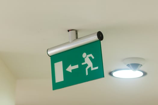 green emergency exit sign in shopping mall. photo