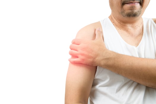A middle aged man in white veat suffering from arm and shoulder pain isolated on white. photo