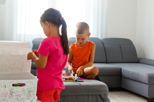 Children play with a toy designer on the floor of the children's room. Two kids playing with colorful blocks. Kindergarten educational games. photo