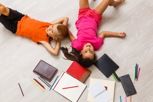 Kids reading for school lying on floor at home photo