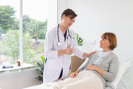 the doctor is examining the patient in the hospital Caucasian doctor wearing gown and a stethoscope talking to a female patient at the hospital photo