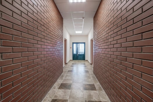 white empty long corridor with red brick walls in interior of modern apartments, office or clinic photo