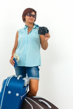 Young woman ready to holiday with camera, paper map and suitcase. photo