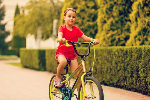 Child riding bike. Kid on bicycle in sunny park. Little girl enjoying bike ride her way to school warm summer day. Preschooler learning to balance bicycle Sport for kids. photo