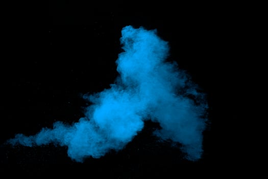 Blue  color powder explosion cloud on black background. Closeup of Blue  dust particles splash. photo