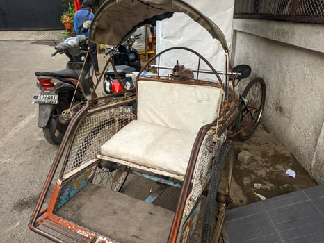 a close up of indonesian rickshaw or becak with white seat photo