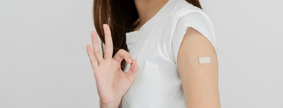 Portrait of pretty, beautiful asian young, teenage attractive after getting, receive anti virus vaccine covid-19. Showing arm on white bandage isolated on white background, copy space. photo