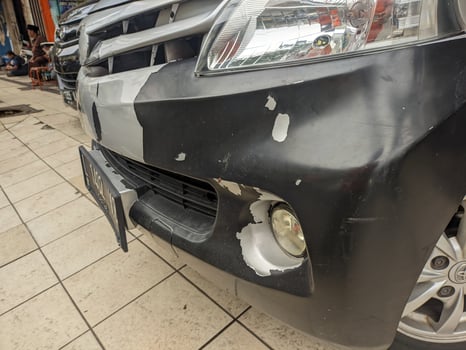 A car front bumper with peeling white paint photo