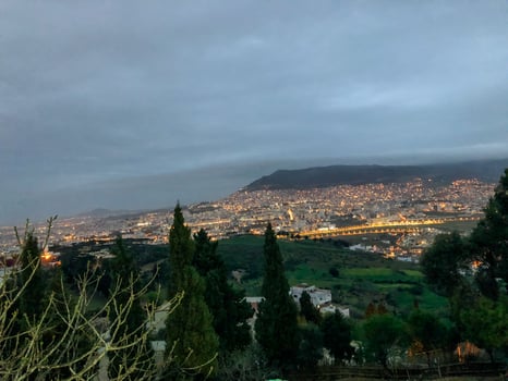 Mesmerizing and illuminating night view of the bustling city of Tetouan, capturing its stunning cityscape and illuminating skyline under the cloudy photo