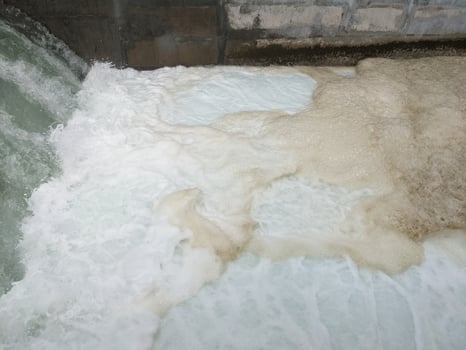 Texture and surface of seawater fall on the power plant with foaming on the outfall. The photo is suitable to use for industry background, environment poster and nature content.