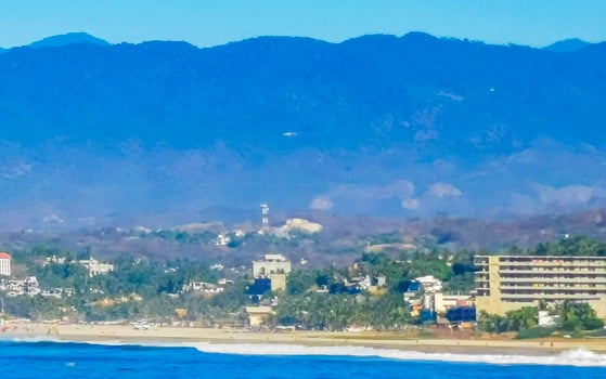 Sun beach cliffs rocks waves palms mountains Puerto Escondido Mexico. photo