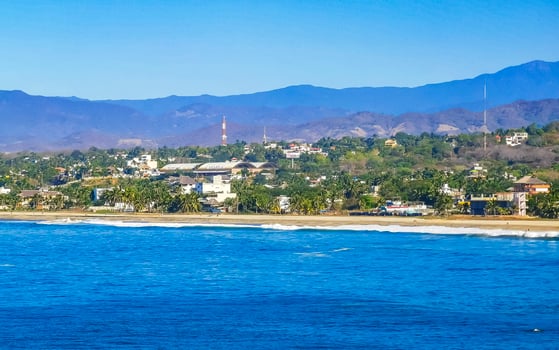 Sun beach cliffs rocks waves palms mountains Puerto Escondido Mexico. photo