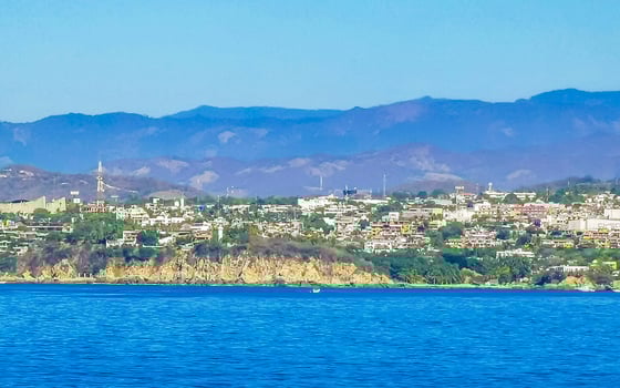 Sun beach cliffs rocks waves palms mountains Puerto Escondido Mexico. photo
