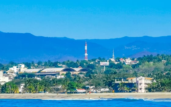 Sun beach cliffs rocks waves palms mountains Puerto Escondido Mexico. photo
