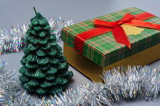A box with a gift for Christmas and New Year, a green gift box with a red ribbon bow on a gray background photo