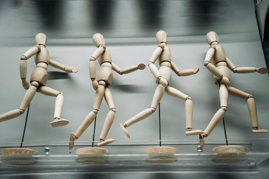 wooden figures of people running after each other photo