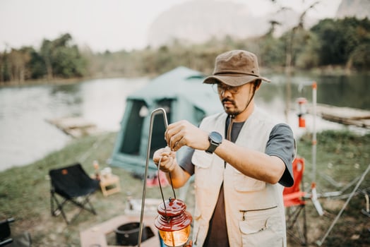 Asian young man setting up lanterns in camping photo